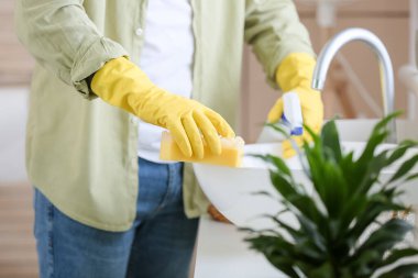 Genç adam banyoyu temizliyor.