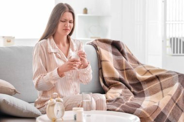 Evde hap alan genç bir kadın.