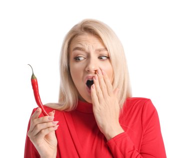 Beyaz arka planda kırmızı biberle şok olmuş genç bir kadın.