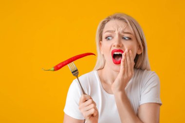 Arka planda kırmızı biberle şok olmuş genç bir kadın.