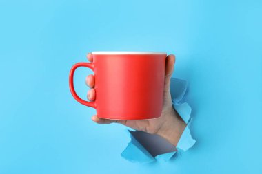 Renk arkaplan üzerinde fincan ile el