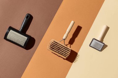 Renkli arka planda evcil hayvan için tımar fırçaları ile yaratıcı kompozisyon