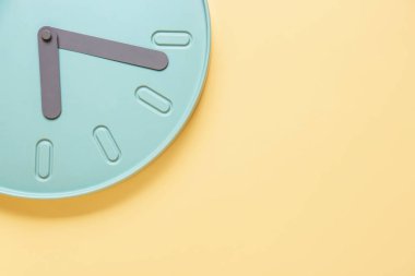 Renkli duvarda asılı şık bir saat, yakın plan.