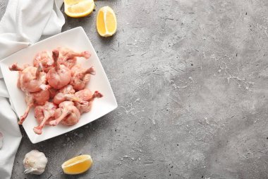 Gri arka planda çiğ tavuk lolipopları.