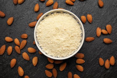 Koyu arkaplanda badem unu olan kase