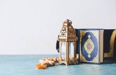 Müslüman lamba, tasbih ve Kuran masaya.
