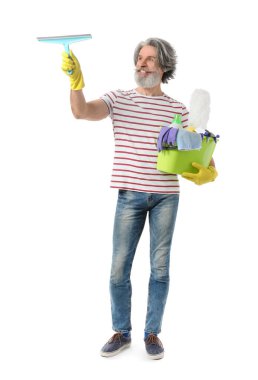 Beyaz arka planda temizlik malzemeleri olan olgun bir adam.