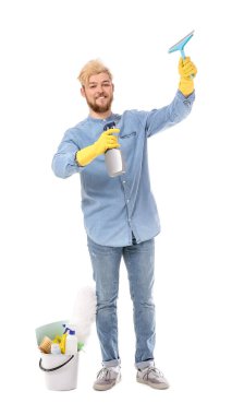 Beyaz arka planda temizlik malzemeleri olan genç bir adam.