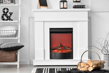 Oturma odasının iç tarafında yakacak odunları olan şık şömine rafı.