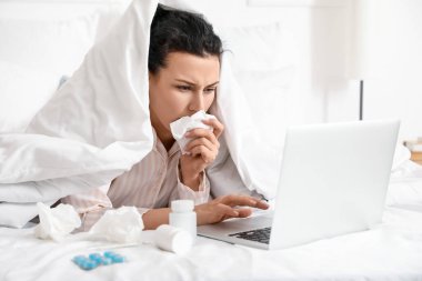 Evde çalışan dizüstü bilgisayarı olan hasta genç bir kadın.