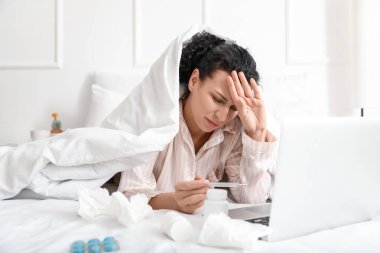 Evde çalışan dizüstü bilgisayarı olan hasta genç bir kadın.