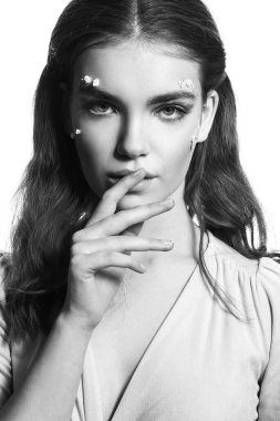 Beyaz arka planda yaratıcı makyajı olan güzel bir kadının siyah beyaz portresi.