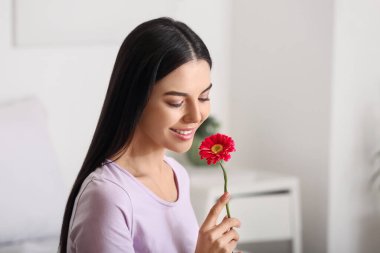 Evinde çiçekli güzel bir kadın.
