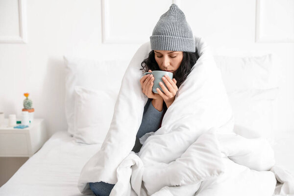 Больная молодая женщина с горячим чаем дома