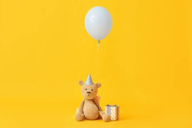 Oyuncak ayılı hava balonu ve renkli arka planda hediye
