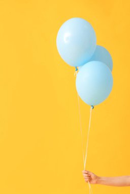 Arka planda hava balonları olan insan eli