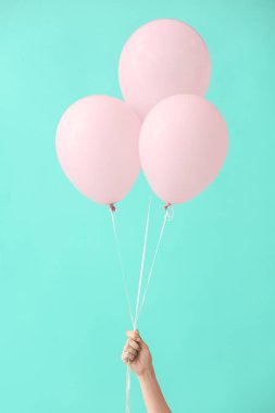 Arka planda hava balonları olan insan eli