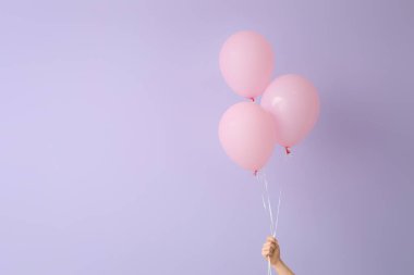 Arka planda hava balonları olan insan eli