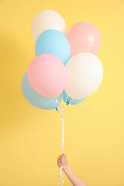 Arka planda hava balonları olan insan eli