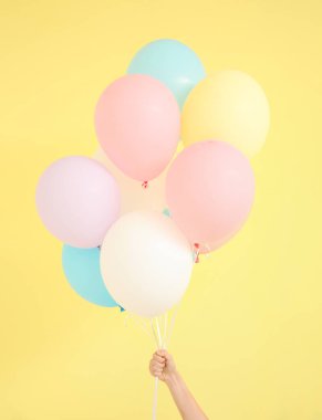 Arka planda hava balonları olan insan eli