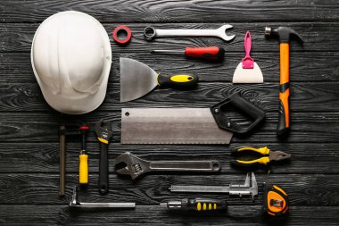 Koyu ahşap arka planda inşaat araçları kümesi