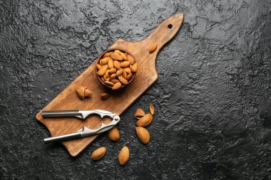 Fındıkkıran ve koyu arkaplanda sağlıklı badem.