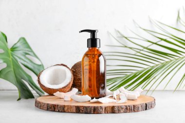 Hafif arka planda hindistan cevizi yağı şişesi ile kompozisyon