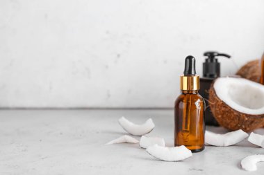 Hafif arka planda hindistan cevizi yağı şişesi ile kompozisyon