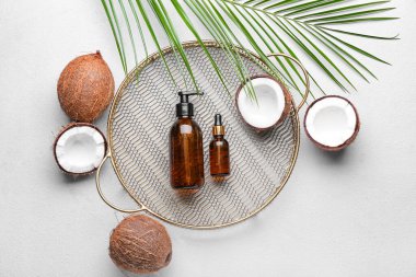 Işık arka planında hindistan cevizi yağı şişeleri ile kompozisyon