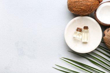 Işık arka planında hindistan cevizi yağı şişeleri ile kompozisyon