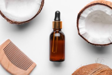 Hindistan cevizi yağı şişesi ve beyaz arka planda tarak bileşimi