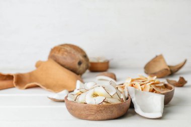 Hafif ahşap zemin üzerinde lezzetli hindistan cevizi parçaları olan kaseler.