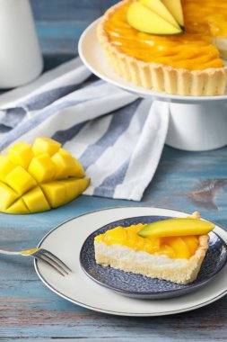 Renkli ahşap arka planda lezzetli bir mango turtası tabağı.