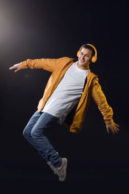 Yakışıklı genç adam müzik dinliyor ve dans ediyor.