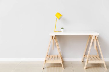 Odada, ışık duvarı yakınında rahat bir iş yeri.