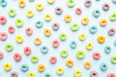 Renkli arkaplanda lezzetli mısır gevreği halkaları, yakın plan