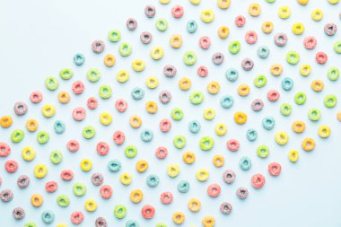 Renkli arkaplanda lezzetli mısır gevreği halkaları, yakın plan