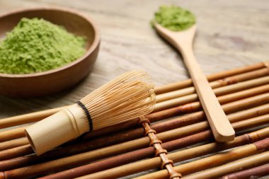 Ahşap arka planda bir kase pudralı kibrit çayı ile kompozisyon, yakın plan.