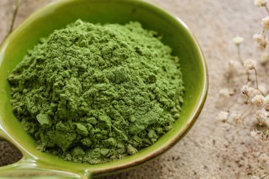 Hafif arka planda pudralı kibrit çayı ile kase, yakın plan.