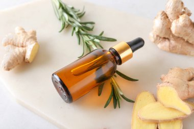 Hafif arkaplanda zencefil esanslı yağ şişesi