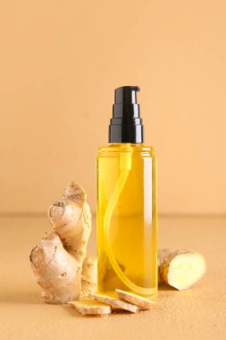 Renkli arka planda zencefil esaslı yağ şişesi