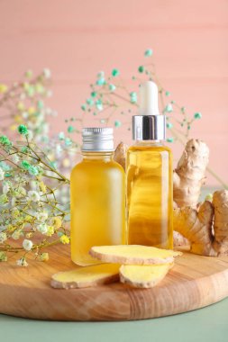 Zencefilli şişeler ahşap arka planda gerekli yağ