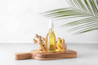 Hafif arkaplanda zencefil esanslı yağ şişesi