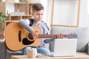 Küçük çocuk evde müzik dersleri alıyor.