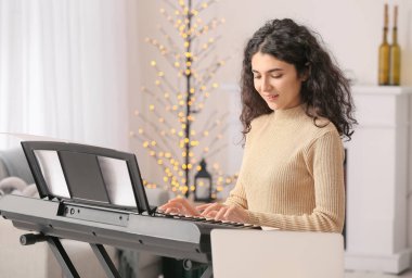 Evde müzik dersleri veren genç bir kadın.