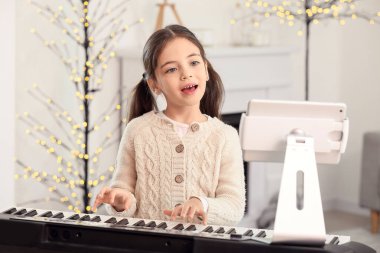 Küçük kız evde müzik dersleri alıyor.