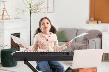 Küçük kız evde müzik dersleri alıyor.