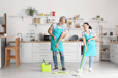 Olgun çift mutfağını temizliyor.