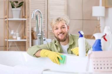 Genç adam banyoyu temizliyor.