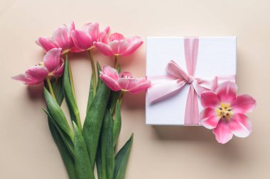 Renkli arkaplanda güzel çiçekler olan hediye kutusu